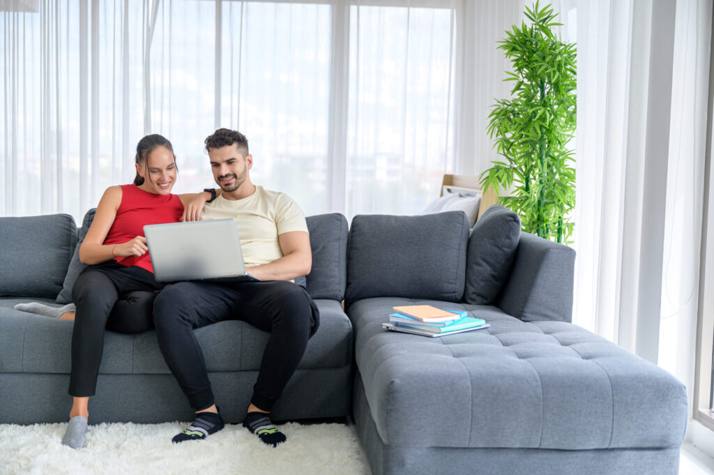 Ontspannen gezin dat samen tijd doorbrengt terwijl ouders hun gezinsbudget en geldplan beheren met een handige app