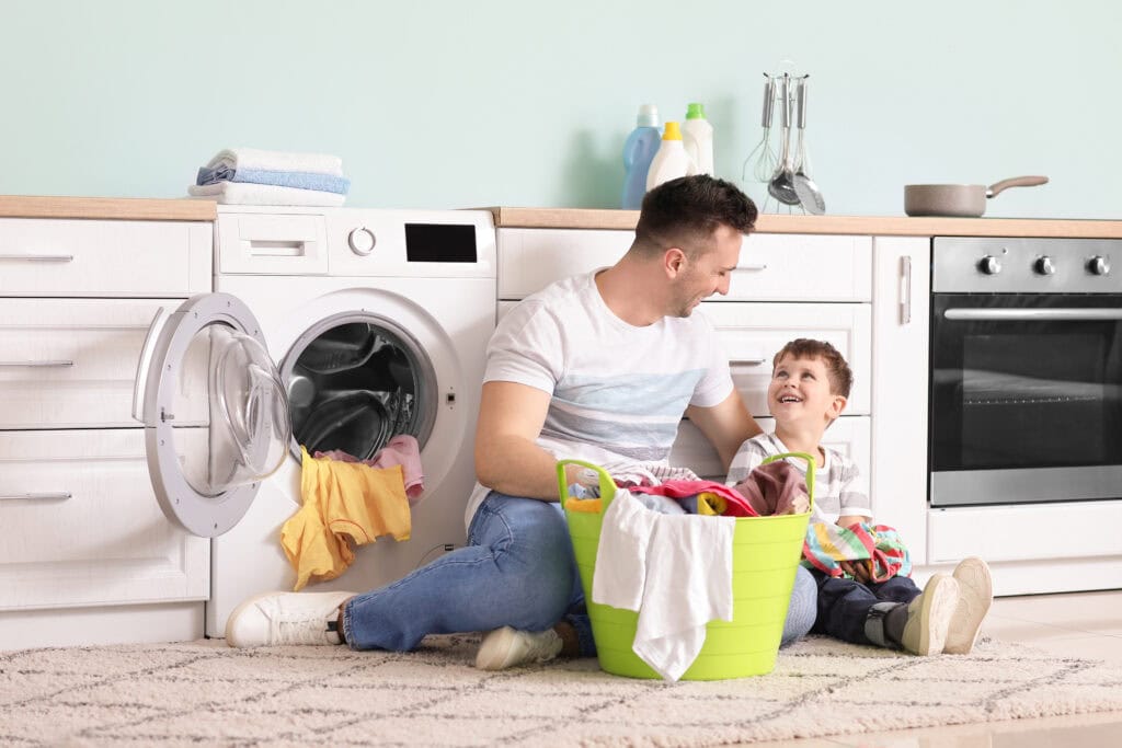 Man met taakverdeling in het huishouden voor de wasmachine